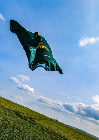 Maillot vert ArdenSport flottant dans le ciel au-dessus d’un champ